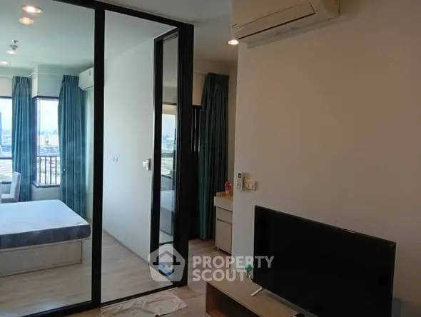 Modern apartment interior with bedroom and living area, featuring sleek design and natural light.