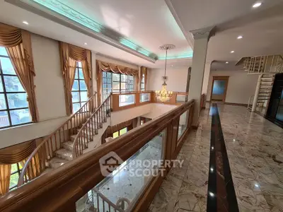 Luxurious interior with grand staircase and elegant marble flooring in a spacious living area.
