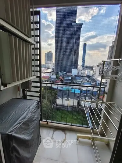 Compact balcony with city view, featuring laundry area and drying racks.