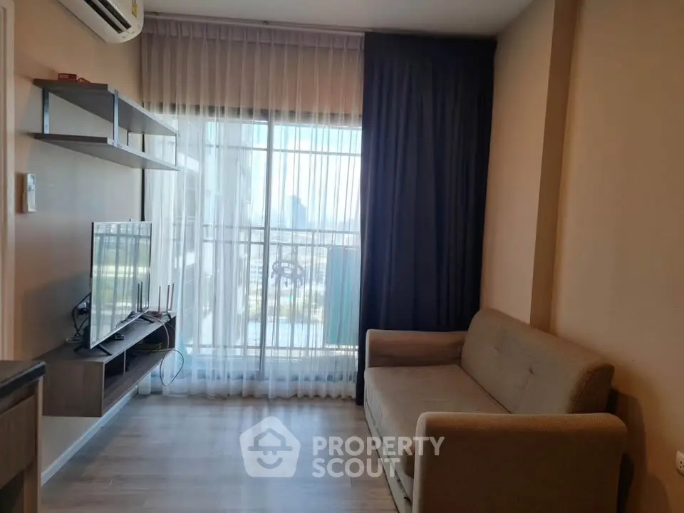 Modern living room with large window and city view, featuring a cozy sofa and wall-mounted TV.