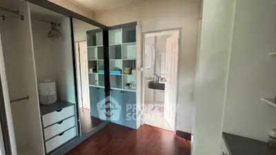 Spacious bedroom with mirrored wardrobe and ensuite bathroom in modern apartment.