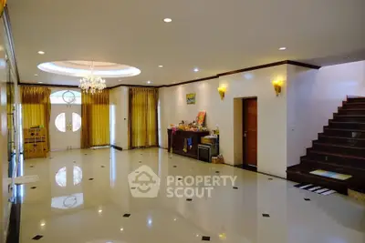 Spacious living room with elegant chandelier and polished flooring