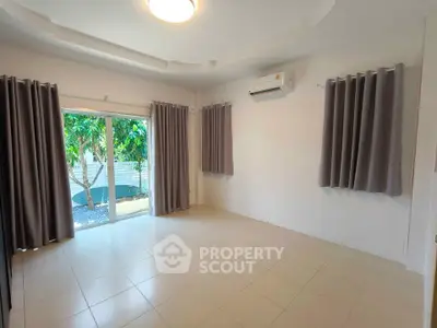 Spacious unfurnished room with large windows and air conditioning, perfect for customization.