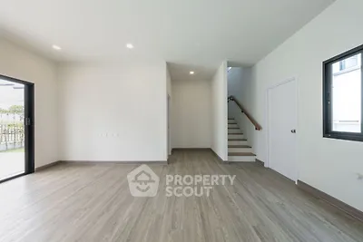 Spacious modern living room with wooden flooring and staircase