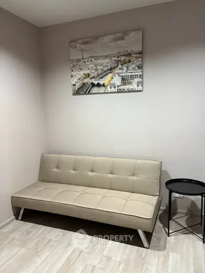 Modern minimalist living room with beige sofa and cityscape artwork