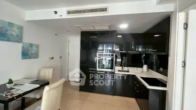 Modern kitchen with sleek black cabinetry and built-in appliances in a stylish apartment.