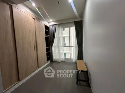 Spacious bedroom with large wardrobe and natural light from window