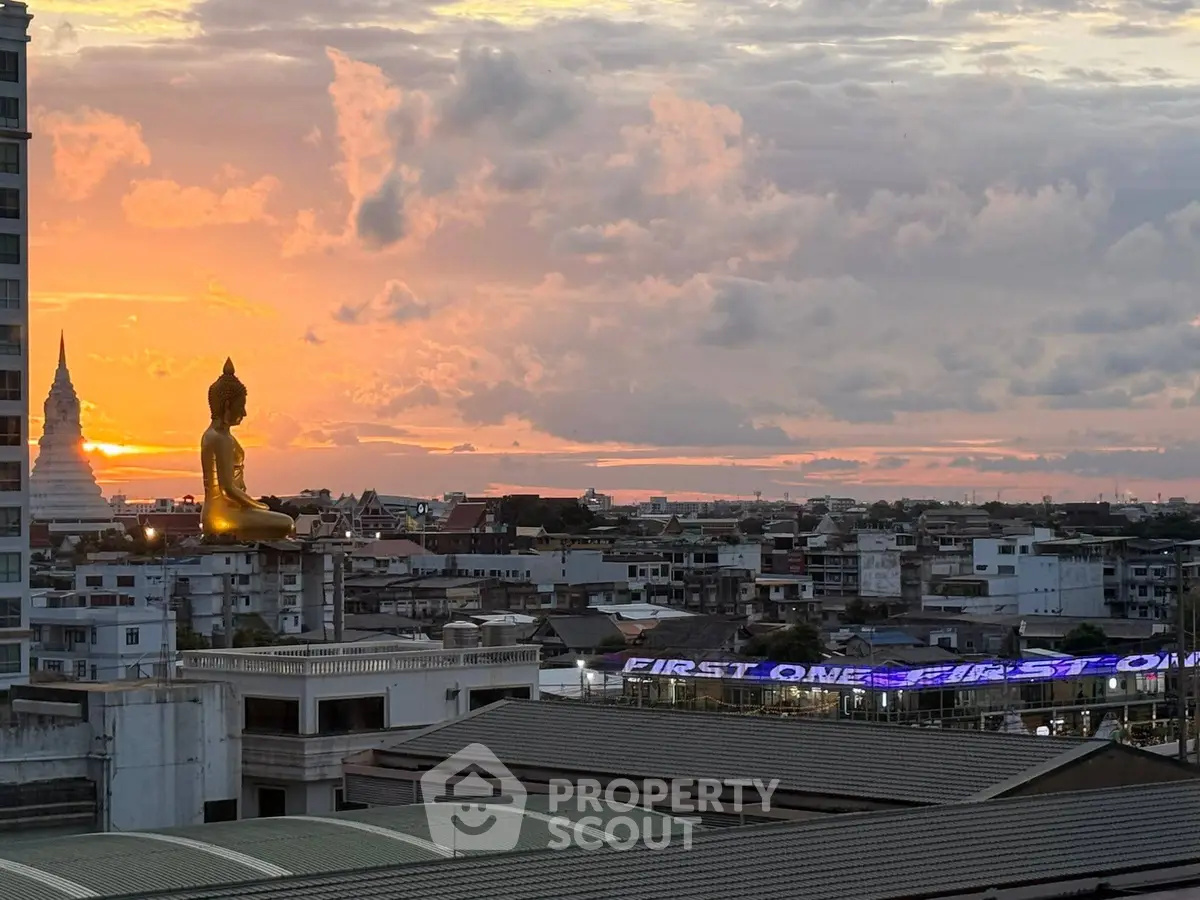 Stunning cityscape view with golden Buddha statue at sunset, perfect for urban living enthusiasts.