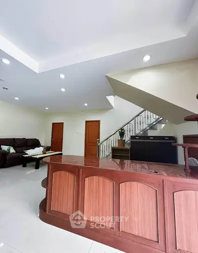 Spacious living room with elegant staircase and modern furniture