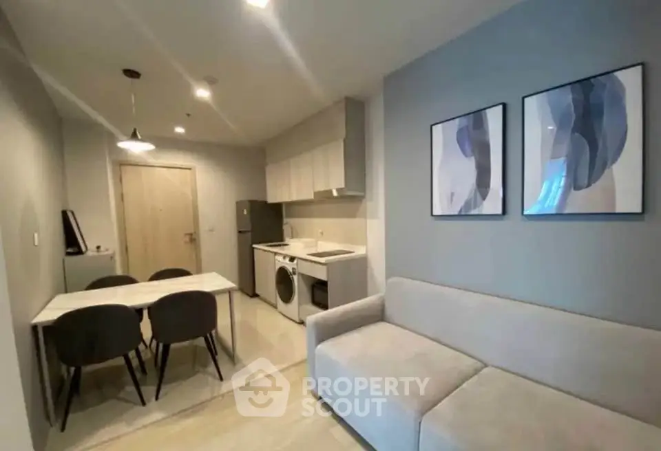 Modern living room with dining area and compact kitchen in stylish apartment.