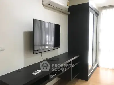 Modern living room with wall-mounted TV and sleek black furniture