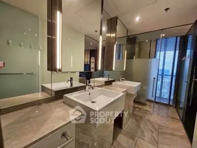 Luxurious modern bathroom with dual sinks and elegant lighting in high-rise apartment.