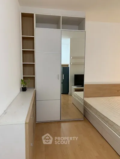 Modern bedroom with mirrored wardrobe and wooden flooring