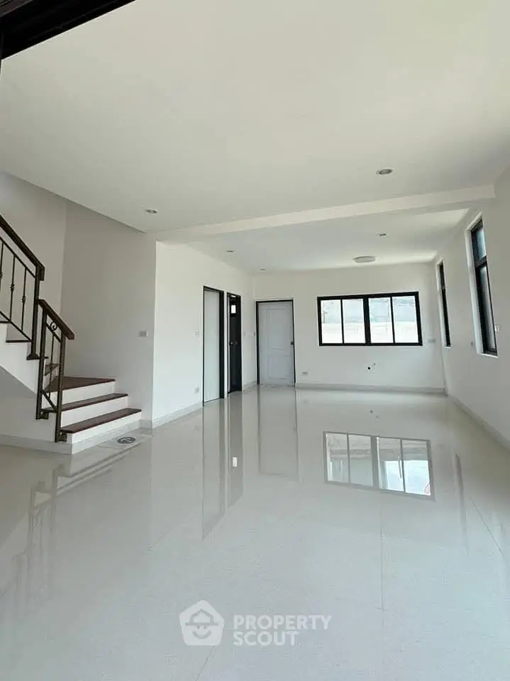 Spacious modern living room with glossy floors and staircase