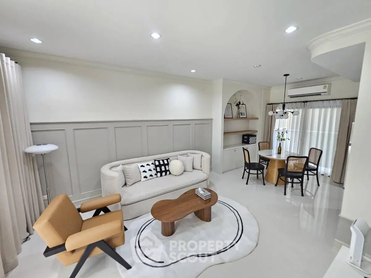 Modern living room with elegant decor and dining area, featuring stylish furniture and ambient lighting.
