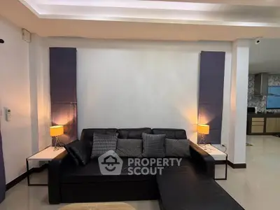 Modern living room with sleek black sofa and ambient lighting