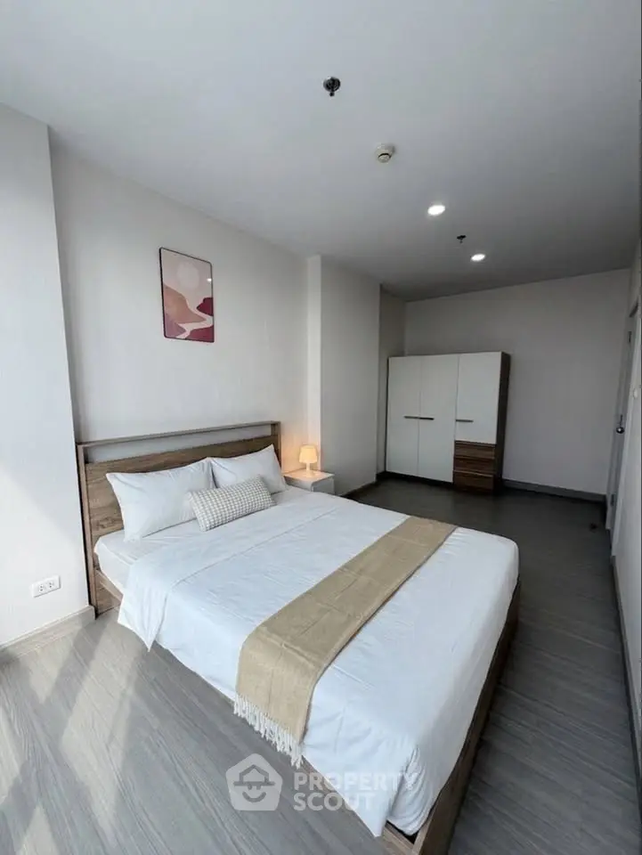 Spacious modern bedroom with stylish decor and ample natural light, featuring a cozy bed and sleek wardrobe.