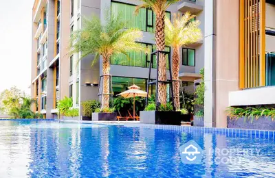 Luxurious apartment building with stunning poolside view and lush palm trees.