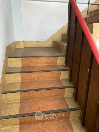 Vintage staircase with wooden railing and retro flooring in a classic building.