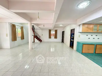 Spacious open-plan living area with tiled flooring and natural light