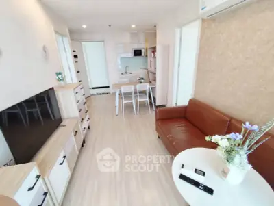 Modern living room with open kitchen, stylish furniture, and bright decor in a cozy apartment.