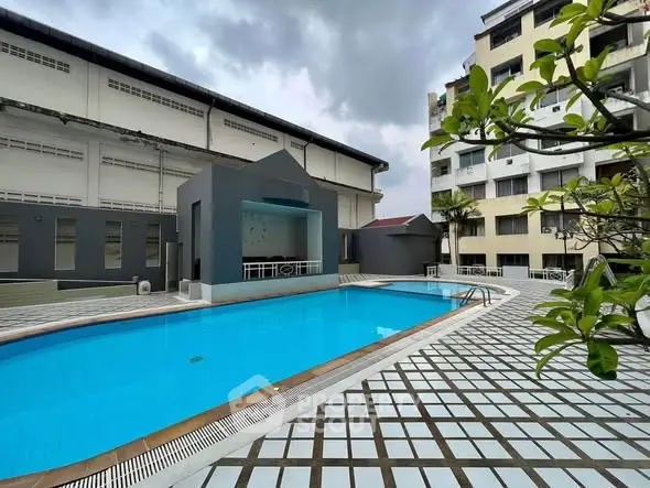 Modern apartment complex with a pristine swimming pool and spacious deck area.