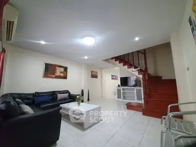 Spacious living room with modern decor and staircase in a stylish home