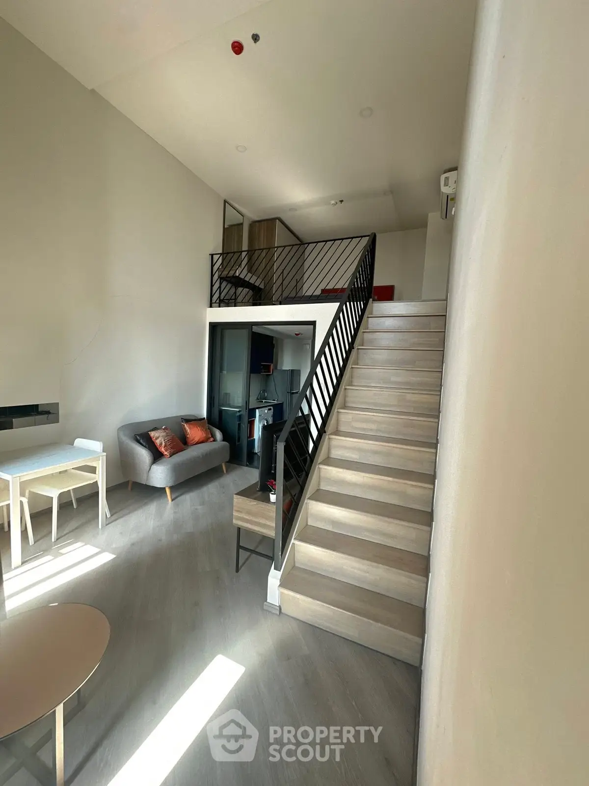 Modern loft-style living room with mezzanine and stylish staircase