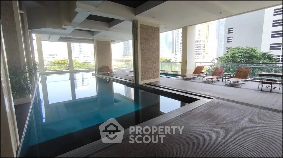 Luxurious indoor pool area with modern design and city view, perfect for relaxation and leisure.