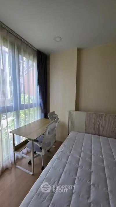 Bright bedroom with large window and study desk, perfect for natural light lovers.