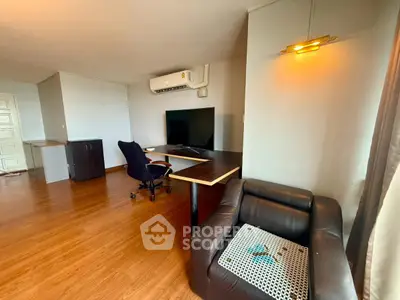 Spacious living room with modern furniture and large TV, perfect for relaxation and entertainment.