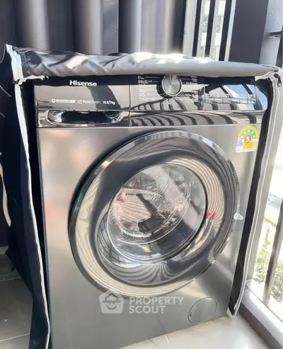 Modern Hisense washing machine on a balcony with city view, perfect for urban living convenience.