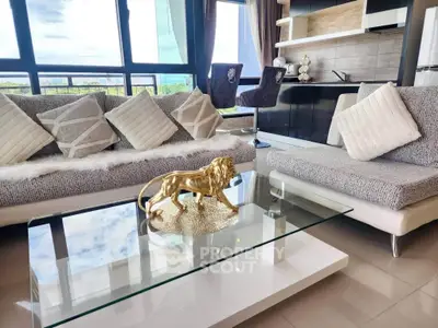 Luxurious modern living room with stylish decor and open kitchen layout, featuring a glass coffee table and plush seating.