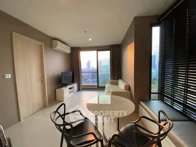 Modern living room with city view, stylish furniture, and natural light.