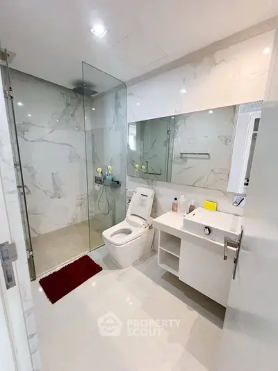 Modern bathroom with glass shower and sleek white fixtures