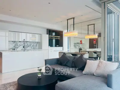 Luxurious open-plan living room and kitchen with modern decor and elegant lighting.