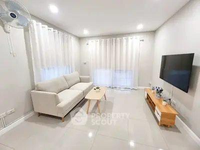 Modern living room with sleek furniture and wall-mounted TV