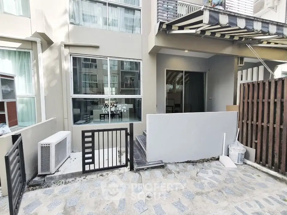 Modern townhouse exterior with patio and large windows in urban setting