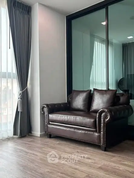 Stylish living room with elegant leather sofa and floor-to-ceiling windows for natural light.