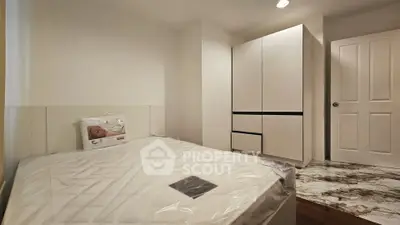 Modern bedroom with sleek white wardrobe and cozy bed setup