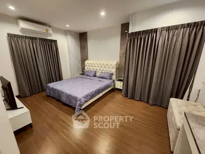 Spacious bedroom with elegant decor and wooden flooring