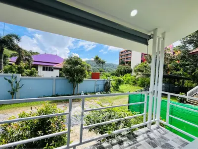 Charming balcony with lush garden view in a serene neighborhood, perfect for relaxation and outdoor enjoyment.