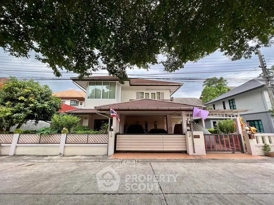 Charming two-story house with lush greenery and spacious driveway in a serene neighborhood.
