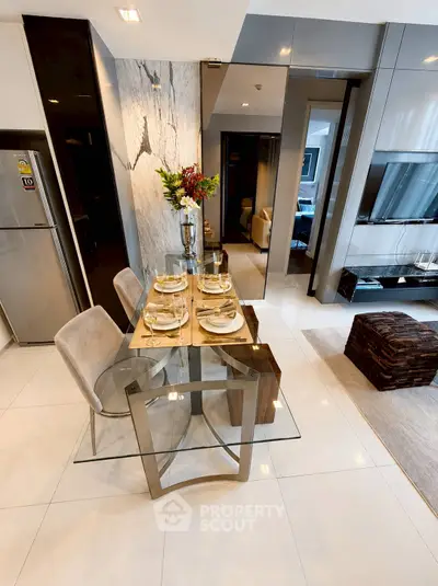 Modern dining area with elegant glass table and stylish decor in a contemporary apartment.