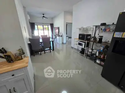 Modern open-plan kitchen and dining area with sleek appliances and stylish decor.