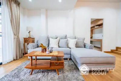 Spacious living room with elegant gray sectional sofa and wooden coffee table.