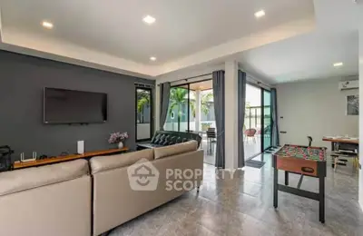 Spacious modern living room with sleek furniture and large windows offering natural light.