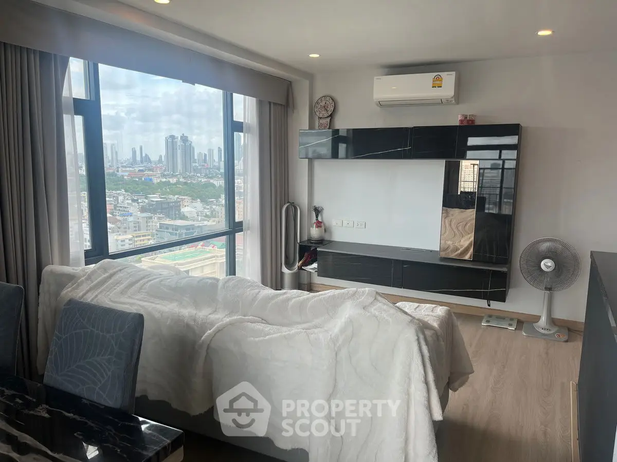 Modern living room with city view, sleek furniture, and air conditioning unit.