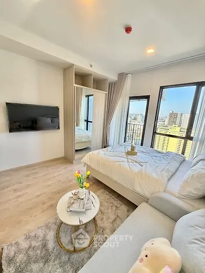 Modern bedroom with city view, cozy seating, and stylish decor