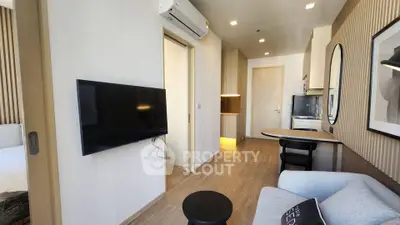 Modern living room with sleek design, featuring a wall-mounted TV, stylish furniture, and wooden flooring.